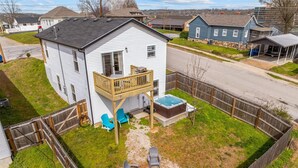 A two-story house with a deck, a hot tub, and outdoor seating. - Trolly Inn Hot Tub, Walkable (Branson)