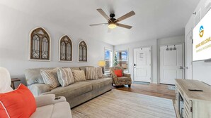 A living room with a sofa, armchairs, a ceiling fan, and a Christmas tree. - Trolly Inn Hot Tub, Walkable (Branson)