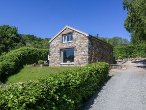 A stone building with a large window, surrounded by greenery. - Holly Cottage, Conwy (Conwy)