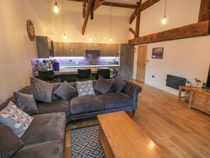 A modern living room with a sofa, a wooden coffee table, and a kitchen in the background. - Flying Scotsman @ Engine Shed, Whitby (Whitby)