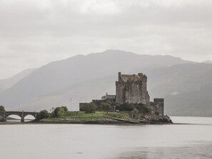 A historic castle on an island with a bridge in the foreground. - Craggan Cottage - Balmacara, Kyle Of Lochalsh (Kyle)
