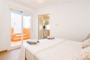 Un dormitorio con cama, baño y vistas al exterior.