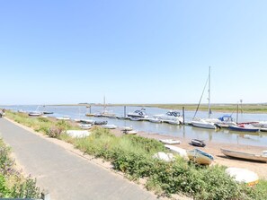A coastal road with boats docked along the shore. - Crab Corner, Wells-Next-The-Sea (Wells-next-the-Sea)
