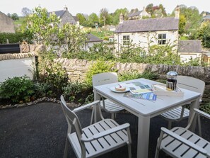 A table with chairs and a tablecloth, a cake, and a menu on a table outside. - The Cottage Bradwell, Bradwell (Hope Valley)