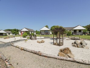 A residential area with houses, a gazebo, and a gravel courtyard.