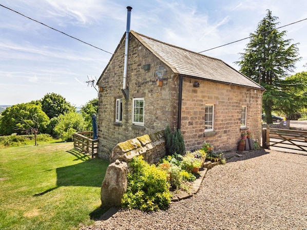 A stone building with a sloped roof, a chimney, and a gravel driveway. - The Old Chapel, Crich (Matlock)