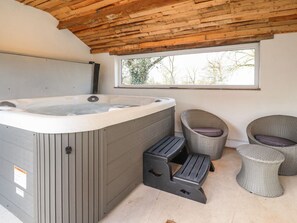 A hot tub with steps, wicker chairs, and a window with a view. - Vine Cottage, Pilling (Preston)