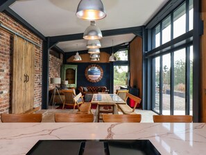 A dining area with a wooden table, chairs, and pendant lighting. - Brock House, in Northallerton. (Northallerton)