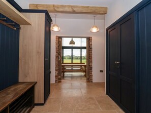 A hallway with a bench, a door, and a view through a window. - Brock House, in Northallerton. (Northallerton)