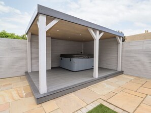 A covered outdoor area with a hot tub, stone flooring, and a white fence. - 4 Bodnant Road, Rhos-On-Sea.TV (Colwyn Bay)