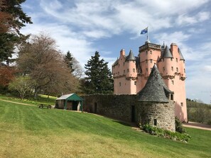 A castle with a stone tower, a picnic area, and a flag on top. - North Mains Cottage, Alford, Aberdeenshire (Alford)
