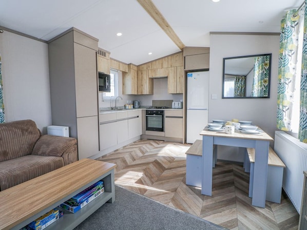 Un espacio habitable compacto con kitchenette, comedor y sofá.