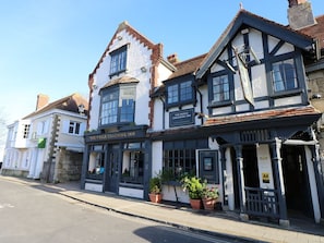 A traditional building with a sign for 'The Pugle Coaching Inn' and a bar area.