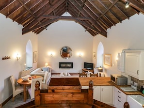 A cozy interior with a dining area, seating, a kitchen, and a high ceiling with exposed beams. - Frogwell Chapel, Callington (Callington)
