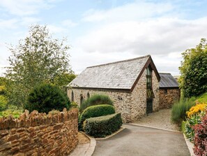 A stone building with a sloped roof, a paved entrance, and a stone wall. - Frogwell Chapel, Callington (Callington)