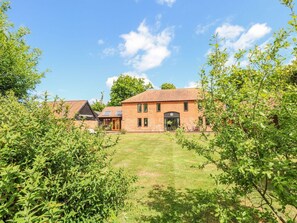A brick building with a tiled roof, a front door, and a small porch. - Lakeside Barn, Aylsham (North Walsham)