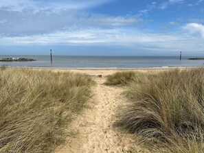 A sandy beach path leading to the ocean with dunes on either side. - Spring Cottage, in Sea Palling (Norwich)