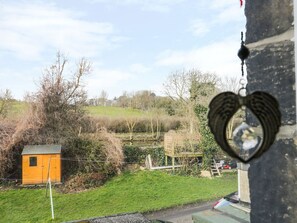 A view of a rural landscape with a small wooden shed, a birdcage on a stand, and a heart-shaped object hanging on a building. - Angel Cottage, Skipton (Skipton)