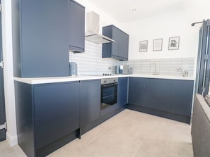 A modern kitchen with dark cabinets, a microwave, and a built-in oven.