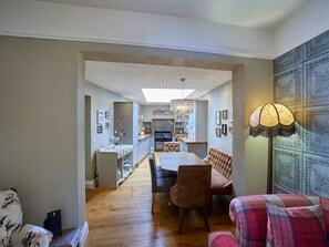 Ein modernes Interieur mit Essbereich, Küche und einer gemütlichen Sitzecke mit Lampe.