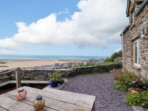 A stone building with a view of the beach and a wooden table with jars. - Pengarreg in Barmouth, Gwynedd (Barmouth)
