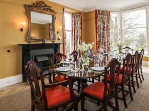 A dining room with a fireplace, a large mirror, and a view of the outdoors. - Auchenvhin in Dalbeattie, 5bed (Dalbeattie)