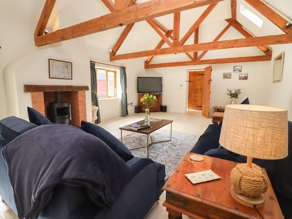 A spacious living room with a fireplace, a television, and a large window.