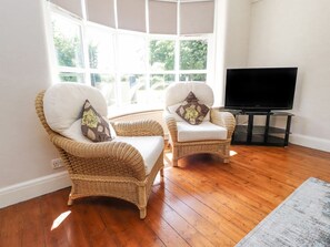 A room with two wicker chairs, a flat-screen TV, and a large window. - Homewood, Garstang, Lancashire (Preston)