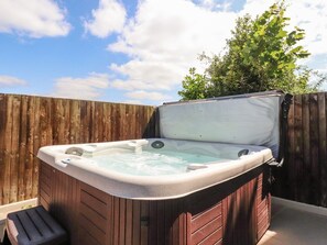 A hot tub with a wooden exterior, a step leading into it, and a wooden fence in the background. - Homewood, Garstang, Lancashire (Preston)