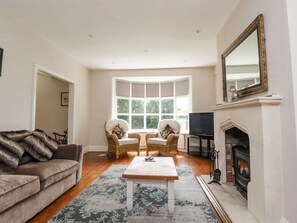 A living room with a sofa, two armchairs, a coffee table, a fireplace, a television, and a large window. - Homewood, Garstang, Lancashire (Preston)