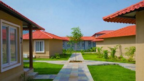 A courtyard with a central pathway leading to a building with a red-tiled roof.