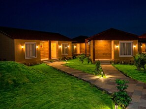 Vista frontal de la propiedad por la tarde o noche