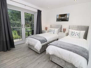 A bedroom with two beds, a balcony, and a view of greenery. - APARTMENT 2: Stylish Living in Whitby (Whitby)