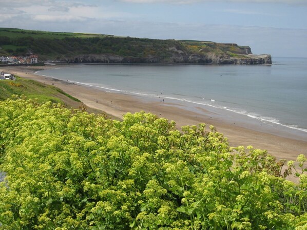 A coastal landscape with a beach, cliffs, and greenery. - APARTMENT 2: Stylish Living in Whitby (Whitby)