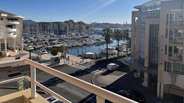 Ein Yachthafen mit Booten, einem Hotel und blauem Himmel.
