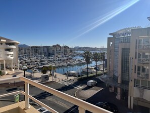 Marina com barcos, um hotel e céu claro.