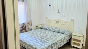 Ein Schlafzimmer mit einem Bett, einem Nachttisch und einem Fenster mit Vorhängen.
