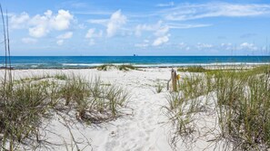 A sandy beach path leading to the ocean with sparse vegetation and a clear sky. - Adorable and affordable gulf front, large 2 bedroom, 2 bath beach home. Salty Heir has so much to offer! (Gulf Shores)