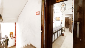 L’entrée d’un hôtel, avec un panneau indiquant la sortie, un escalier et une vue sur le hall d’accueil.