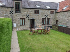 A stone building with a garden, outdoor seating, and a visible entrance. - The Haven is in Northumberland (Berwick-upon-Tweed)