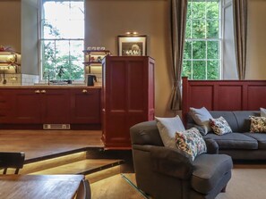 A living room with a dark sofa, a wooden coffee table, and a red cabinet. - The Court, Ingleton, Yorkshire (Carnforth)