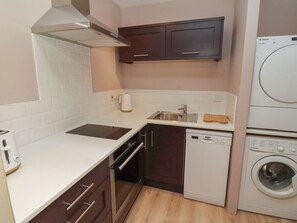 Eine kompakte Küche mit Geschirrspüler, Waschmaschine und Backofen.