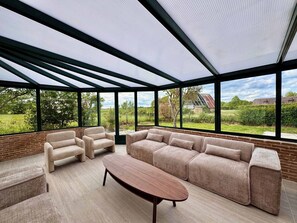 A modern living room with a sectional sofa, two armchairs, and a coffee table.