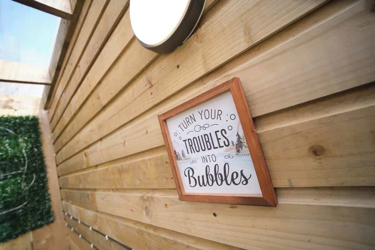 Una pared de madera con un cartel enmarcado que dice 'TRANSFORMA TUS PREOCUPACIONES EN Burbujas'.