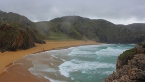 A coastal landscape with a sandy beach, rocky cliffs, and a body of water. - Atlantic View Retreat (Sleeps 6,Pet Friendly,Wifi) (Downings)