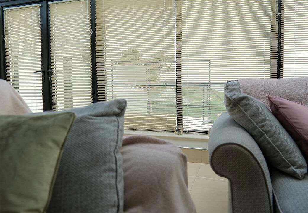A room with a window, a sofa, and a chair.