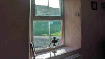 A room with a window, a radiator, and a small table with a lamp.