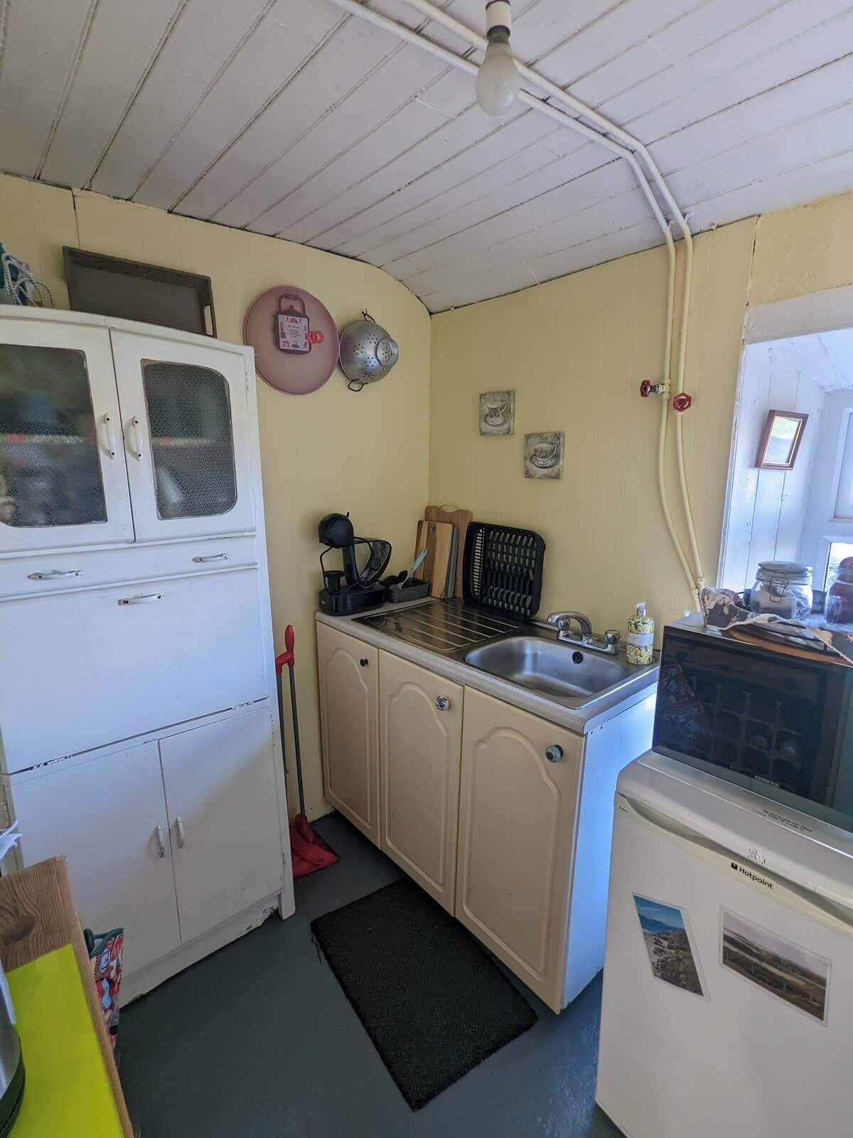 Une cuisine compacte équipée d’un réfrigérateur, d’un évier et d’une cuisinière.