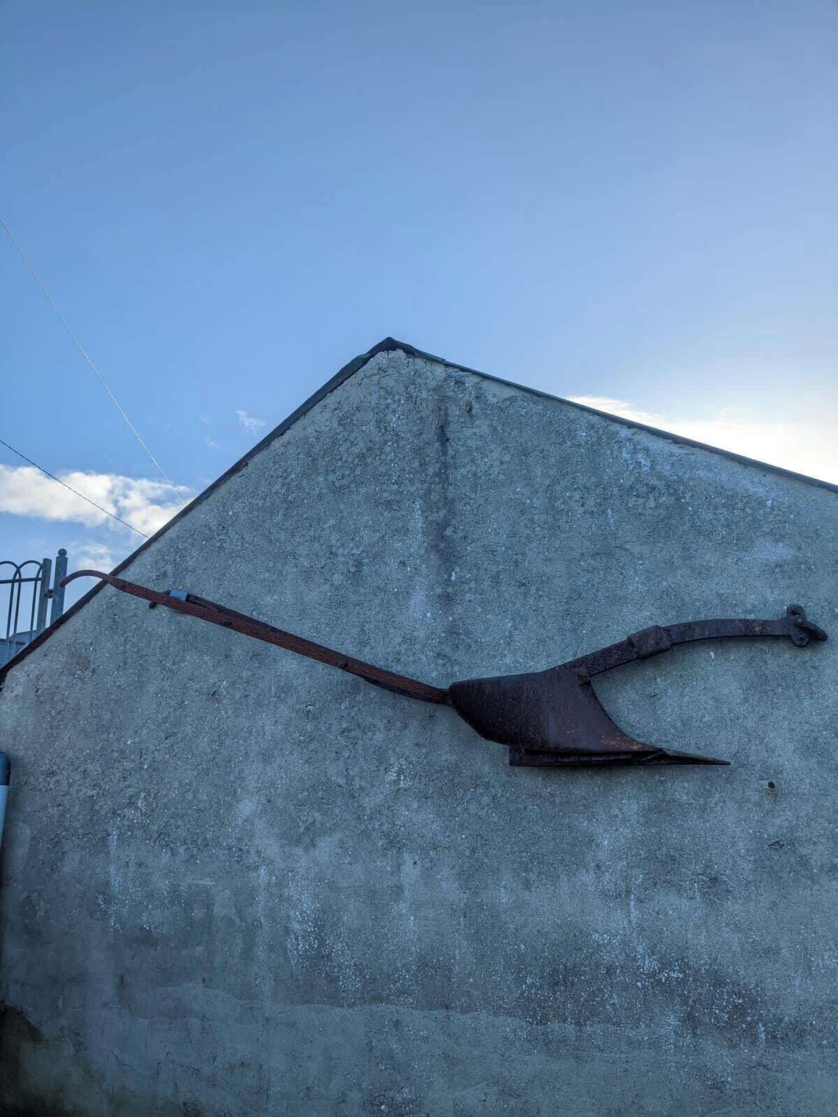 A concrete structure with a metal object resembling a hook or anchor.