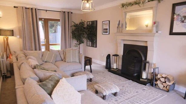A living room with a fireplace, a sofa set, a rug, and a plant. - Modern 4 Bed,3 Bath Detached Home with Sea View (Quigley's Point)